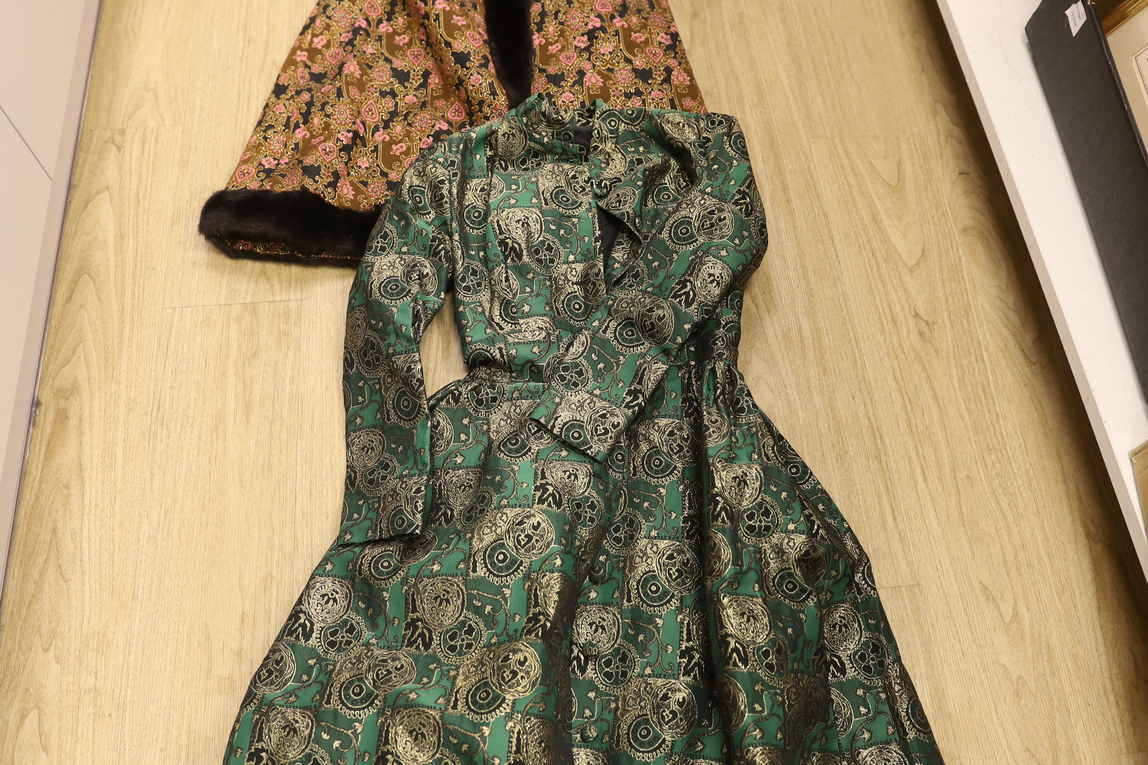 Two late 20th century brocade ladies evening coats, one with fur trimming to the neck, cuffs and bottom of coat